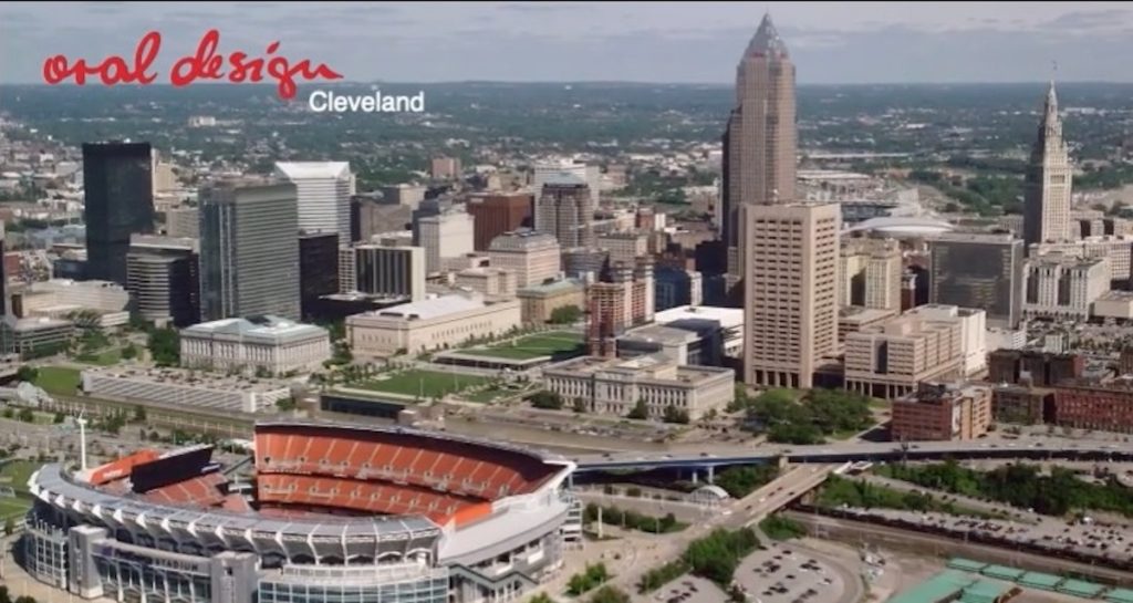 Aerial view of Cleveland skyline featuring the FirstEnergy Stadium, with "oral design Cleveland" text overlay, emphasizing dental services in the local area.