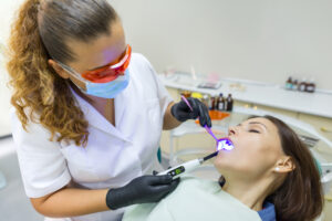 Dental professional performing a procedure on a patient under IV sedation, showcasing a calm dental environment and advanced dental tools.