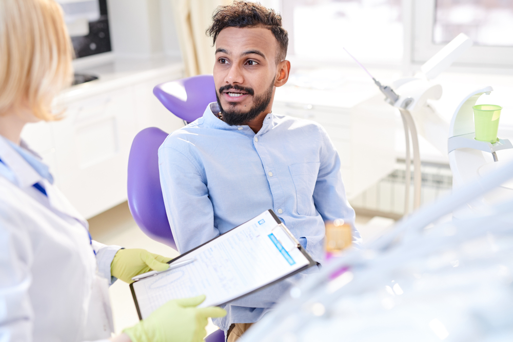 patient discussing costs with dentist while she holds dental chart, showing desire for affordable cosmetic dentistry and dental financing