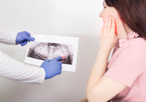 dentist pointing to wisdom tooth area on x-ray