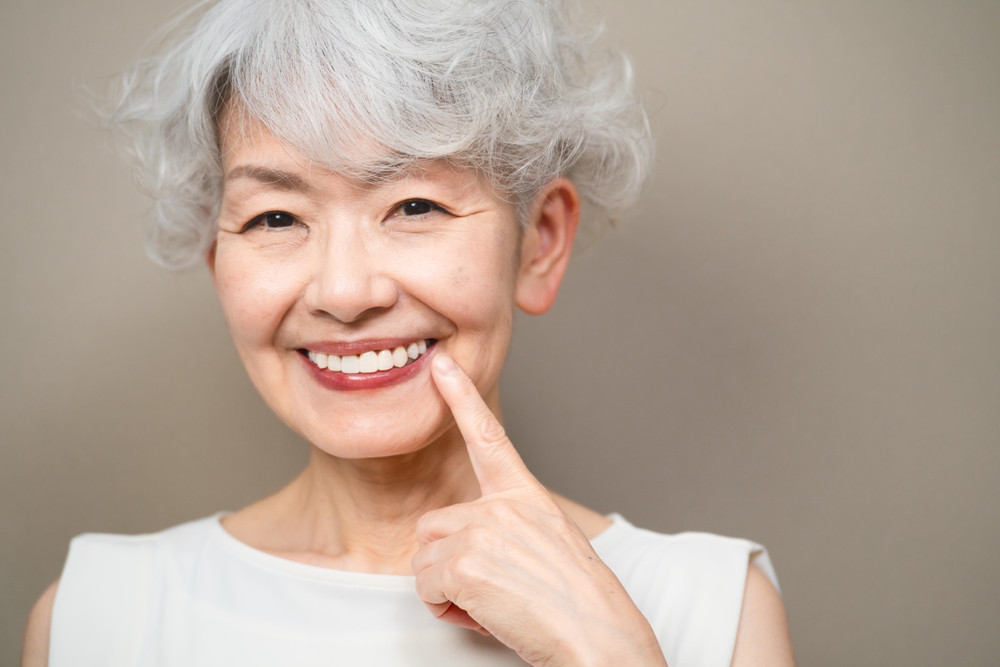 Woman smiling showcasing cosmetic dentistry and aging smile treatment options.